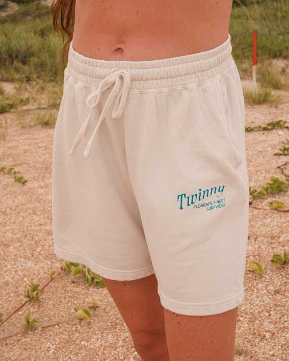 Person wearing white shorts with a brand logo in an outdoor setting