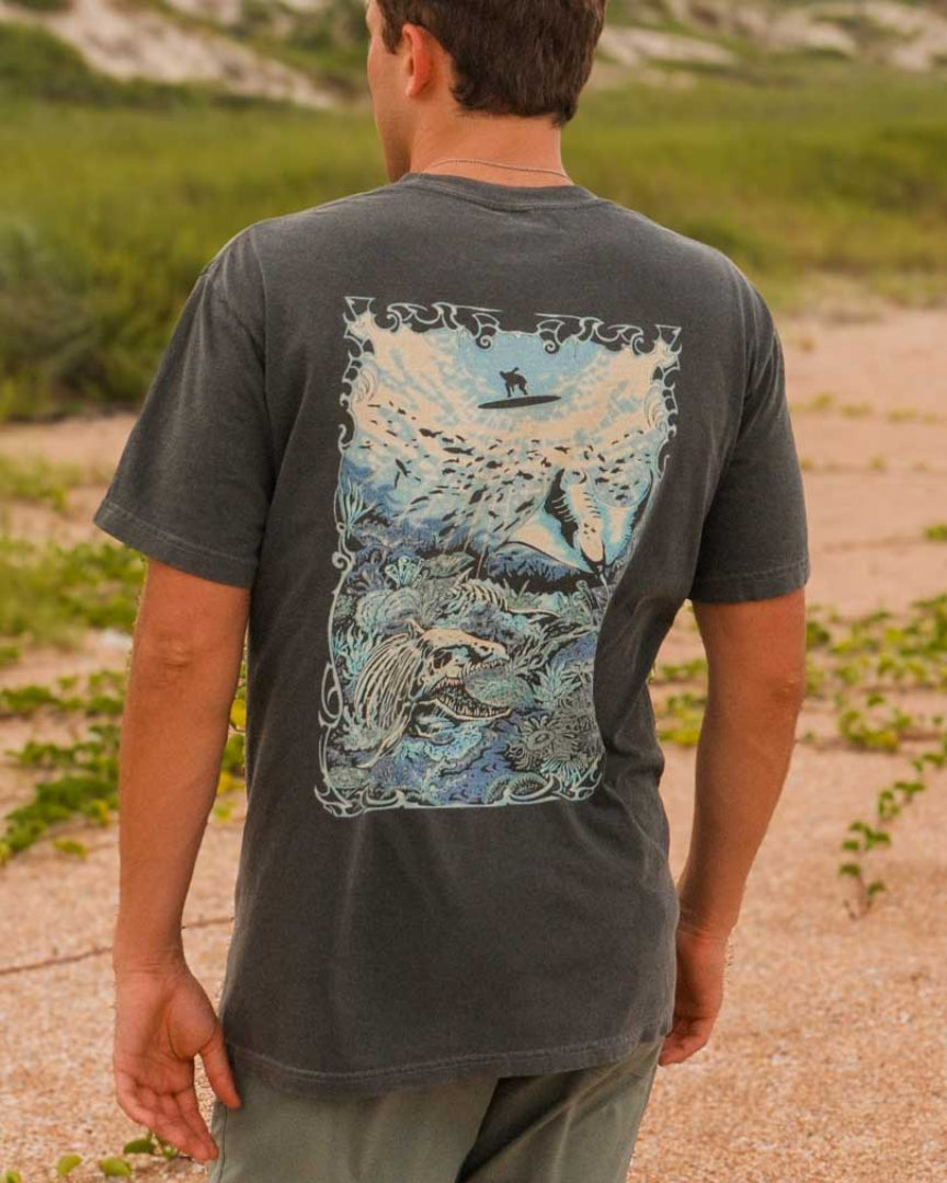 Person wearing a t-shirt with a graphic design on a beach