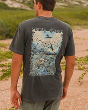 Person wearing a t-shirt with a graphic design on a beach