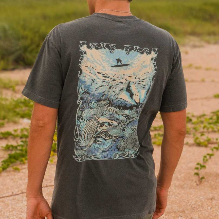 Person wearing a t-shirt with a graphic design on a beach